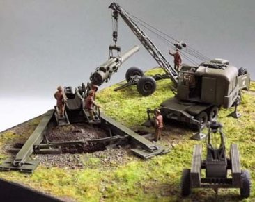 The Gun Chassis (US142) now emplaced, is having the Gun Barrel lowered from the M2A1 Trailer (US141) by the Thew Loraine Crane Truck (US146). Painted diorama by Master pattern maker Neil Craig